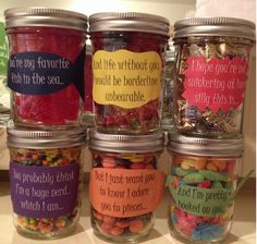 four jars filled with different types of candies on a counter top, each labeled with words and phrases