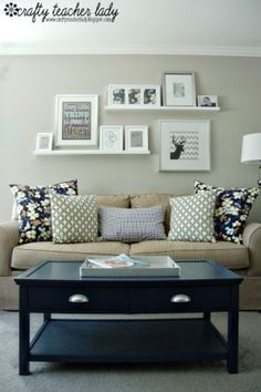 a living room filled with lots of furniture and pictures on the wall above it's coffee table