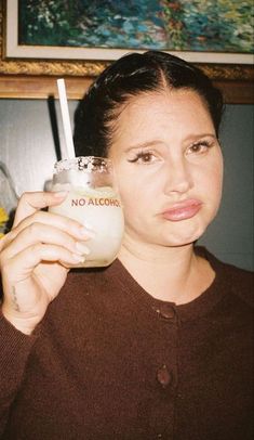 a woman holding a drink in her right hand