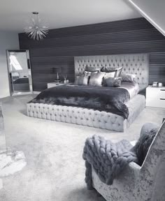 a large bed sitting in the middle of a bedroom next to a chair and dresser