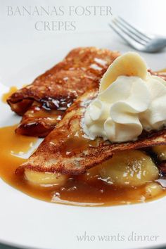 banana fosterer crepes on a white plate with whipped cream and caramel syrup