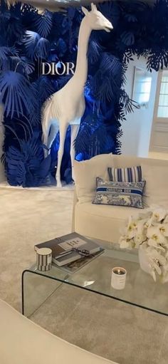 a living room filled with furniture and a giraffe statue on top of a glass table