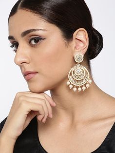 These beautiful off-white circular chandbali earrings come with kundan stone studs, beads & pearls, are gold-plated, and are secured with a post and back closure. These handcrafted classic drop chandbalis are versatile and can be easily paired with most outfits for any festive occasion. Classic with a touch of Bam! Product color may vary based on the monitor or screen you are using.See FAQ for more details. Size Length: 8 cm Details Material: BrassStones: Kundan & Artificial BeadsPlating: Gold-p Heavy Chandbalis For Reception, Festive Kundan Chandbalis With Pearl Drop, Festive Kundan Chandbali Necklace With Pearl Drop, Bollywood Pearl Chandbali Earrings With Pearl Drop, Pearl Drop Chandbalis For Diwali Reception, Pearl Drop Chandbalis For Reception And Diwali, Festive Kundan Chandbali Pearl Earrings, Kundan Chandbalis With Pearl Drop For Reception, Festive Chandbali Kundan Pearl Earrings