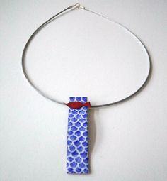 a blue and white necklace with a red bow