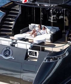 two people lounging on the back of a boat