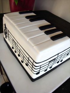 a cake that looks like a piano keyboard with musical notes on the front and sides