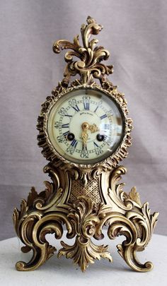 an ornate gold clock with roman numerals