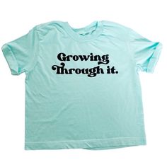 "Growing through all that life brings. Our women's style \"hip t-shirt\" is a women's relaxed fit, women should get their true size. As the name suggests, the shirt runs a bit shorter resting on the hip. If you are on the taller side, the shirt would sit right at the waistline. In the photo model is 5'2, normal size 12 wearing an XL. - see the sizing chart below." Spring Graphic Tee With Lettering, Blue Relaxed Fit Tops With Lettering, Short Sleeve Graphic Tee With Lettering, Graphic Tee With Lettering And Short Sleeves, Relaxed Fit Short Sleeve Shirt With Lettering, Retro Relaxed Fit Tops With Lettering, Family Matching Short Sleeve Tops With Letter Print, Family Matching Tops With Letter Print And Short Sleeves, Cotton Graphic Tee With Lettering