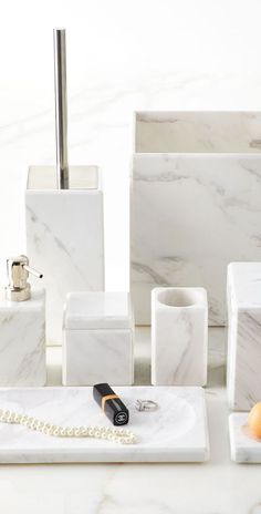 white marble bathroom accessories including soap dispenser, toothbrush holder and pen