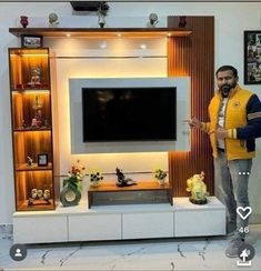 a man standing in front of a tv on top of a white entertainment center with shelves