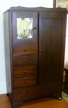 a wooden armoire sitting on top of a hard wood floor