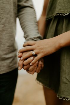 two people holding hands while standing next to each other