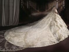 a woman in a white wedding dress is standing on a dark floor with her back turned to the camera