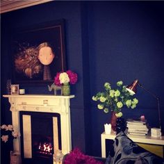 a living room filled with furniture and a fire place in front of a painting on the wall