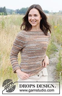 a woman standing in a field with her hands on her hips and smiling at the camera