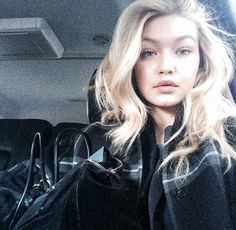 a woman sitting in the back seat of a car with her hand on her purse