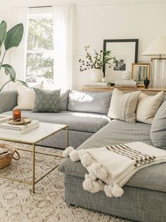 a living room filled with lots of furniture and decor on top of a white rug