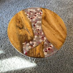 a wooden table topped with rocks and pebbles on top of a gray carpeted floor