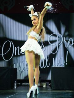 a woman in a white dress is dancing on stage