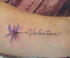 a tattoo with the word valentinea written in cursive writing and a purple flower