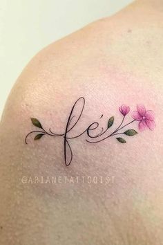 the back of a woman's shoulder with pink flowers on her left arm and an inscription