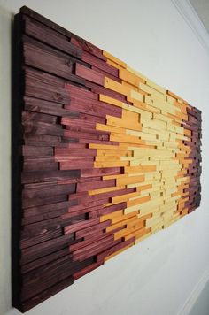 a wooden wall hanging on the side of a white wall