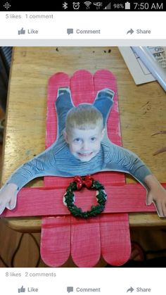 a child is sitting in a chair made out of popsicles and paper with a wreath on it