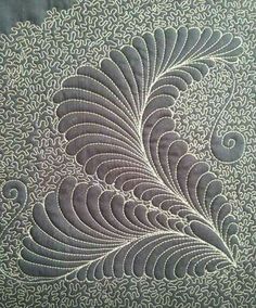 an intricately designed piece of fabric with white thread on the bottom and grey background