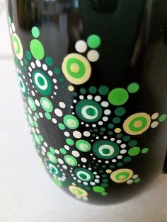 a black cup with green and white designs on it