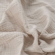 a white blanket is laying on top of a bed sheet that has been folded over