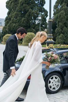 a man and woman walking next to a car