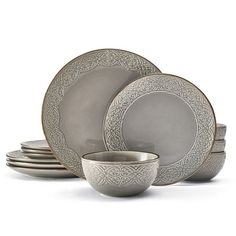 a set of silver dinnerware on a white background with an intricate design in the center