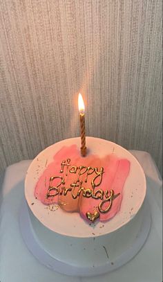 a birthday cake with the words happy birthday written on it and a single lit candle