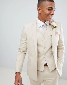 a man in a white suit and flower boutonniere