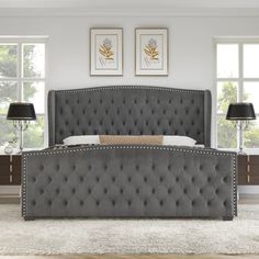 a bed with grey upholstered headboard and two lamps