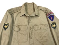 "Vintage 1950s Era US Army Cotton Khaki Shirt w/ original patches (7th Engineer Brigade, Europe SHAEF) FABRIC: 100% cotton  - soft, durable and medium weight overall CONDITION: fair - some patina coloration from storage - this could come out with a proper cleaning - might need a soak (we haven't tried) SIZE: estimated sz XL - please refer to measurements: armpit to armpit: 25\" shoulder to cuff: 22.75\" shoulder to shoulder: 19\" length in back (bottom of collar to hem): 30.25\" shipping weight Retro Khaki Cotton Shirt, Vintage Long Sleeve Tops With Patches, Vintage Button-up Shirt With Patch Pockets, Vintage Khaki Shirt With Pockets, Vintage Long Sleeve Top With Patch Pockets, Vintage Cotton Shirt With Pockets, Vintage Khaki Cotton Top, Usmc Shirts, Khaki Shirt