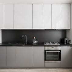 an empty kitchen with white cabinets and black counter tops is pictured in this image from the front view