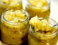 four jars filled with food sitting on top of a table