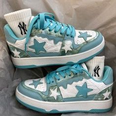 a pair of white and blue sneakers with stars on the soles are sitting on a bed sheet