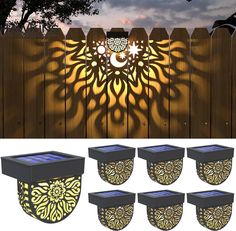 solar powered garden lights in the shape of a sunflower on a wooden fence at night