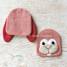 two pink and white animal shaped coasters sitting on top of a wooden table