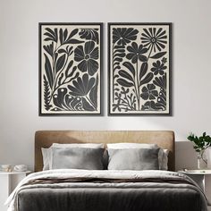 two black and white paintings on the wall above a bed