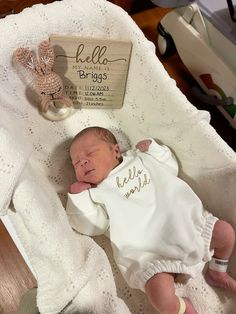 a newborn baby is laying in a crib next to a teddy bear and birth record