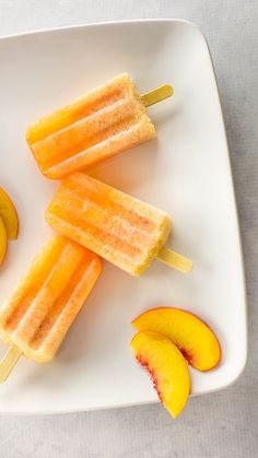 two pieces of fruit on a plate with ice cream and sliced peaches next to them