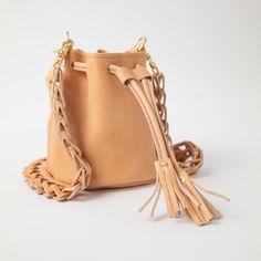 The Natural Essex Mini Bucket Bag is an heirloom-quality bag just like our classic bucket bag, only smaller. Natural Essex is a soft and squishy vegetable-tanned leather that develops a dramatic patina with wear, produced by the iconic Horween tannery in Chicago. The Natural Essex Mini Bucket Bag comes standard with a matching chain link strap, or you can upgrade to a matching two-ply strap. Leather Bucket Bag With Detachable Strap In Natural Color, Natural Leather Bucket Bag With Detachable Strap, Leather Bucket Bag With Removable Pouch In Natural Color, Natural Leather Bucket Bag, Handmade Leather Bucket Bag In Natural Color, Leather Pouch Bucket Bag In Natural Color, Natural Leather Pouch Bucket Bag, Natural Leather Bucket Shoulder Bag, Leather Bucket Bag In Natural Color