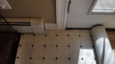 an overhead view of a bathroom with tiled flooring and white door, next to a toilet