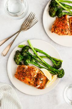 two white plates topped with fish and broccoli