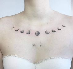 a woman's chest with phases of the moon and stars on her left side