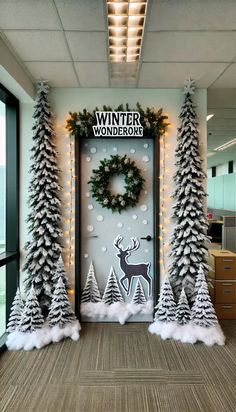 an office decorated for christmas with trees and wreaths on the front door, surrounded by fake snow