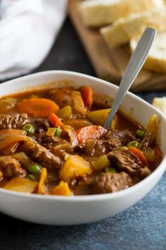 a white bowl filled with beef and vegetables